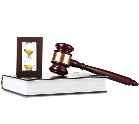 Image of an hourglass and a gavel on top of a book