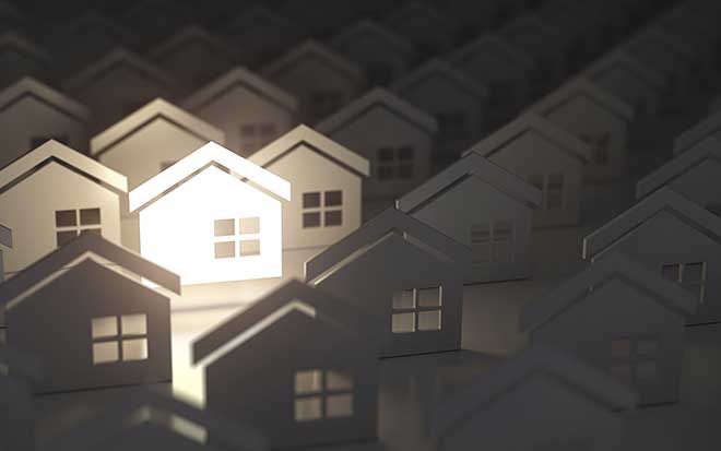 Image of a lit up house amongst many dark houses