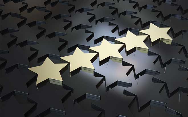 Five gold starts stand out from darker stars across a table.